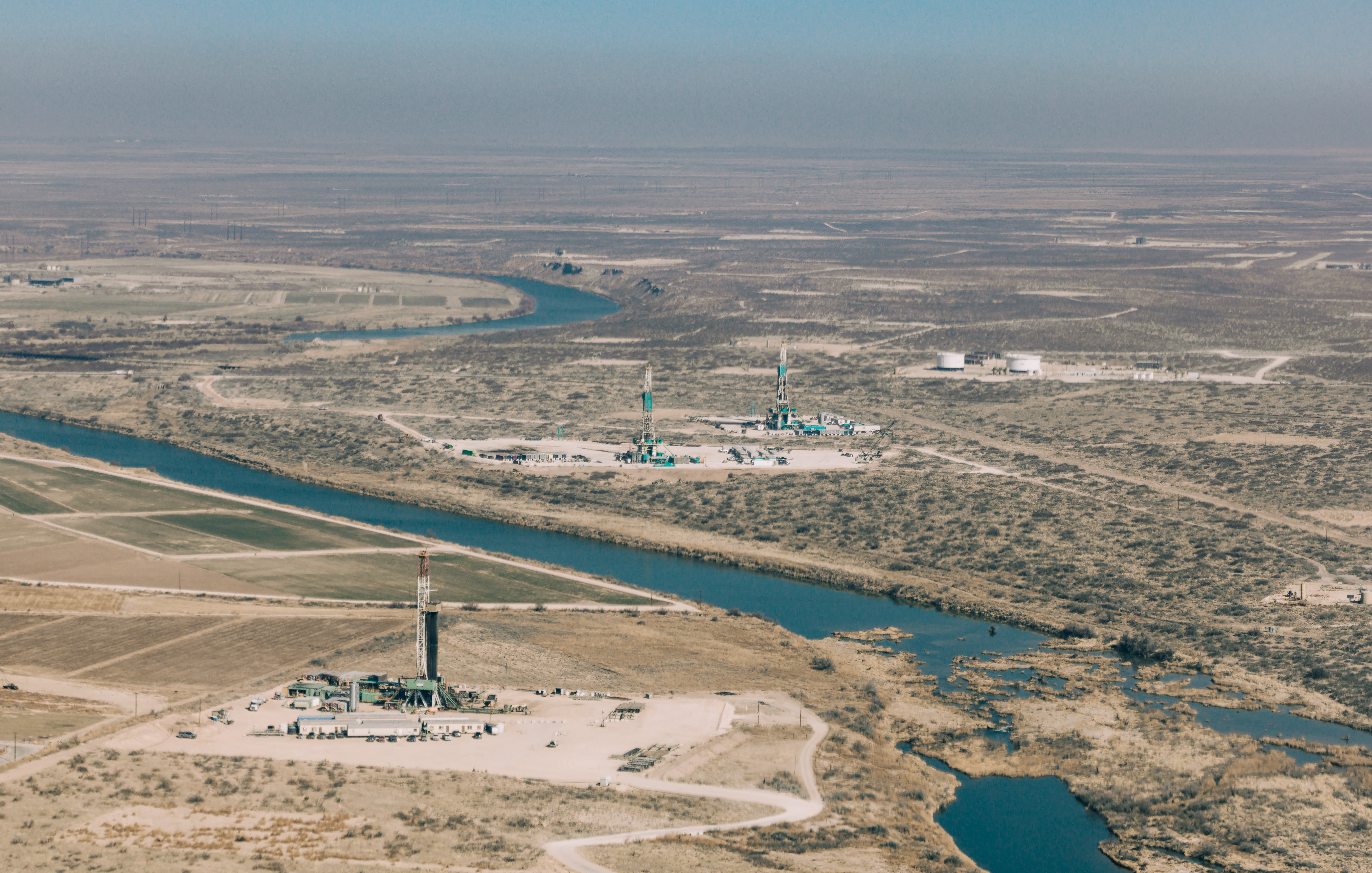 3 drilling rigs alongside the Pecos River outside of Carlsbad, NM